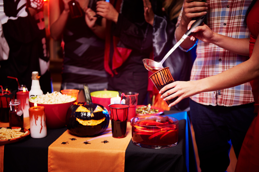 Person getting alcohol from a punch bowl while celebrating Halloween during recovery