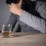 Man with drink struggling with alcohol relapse