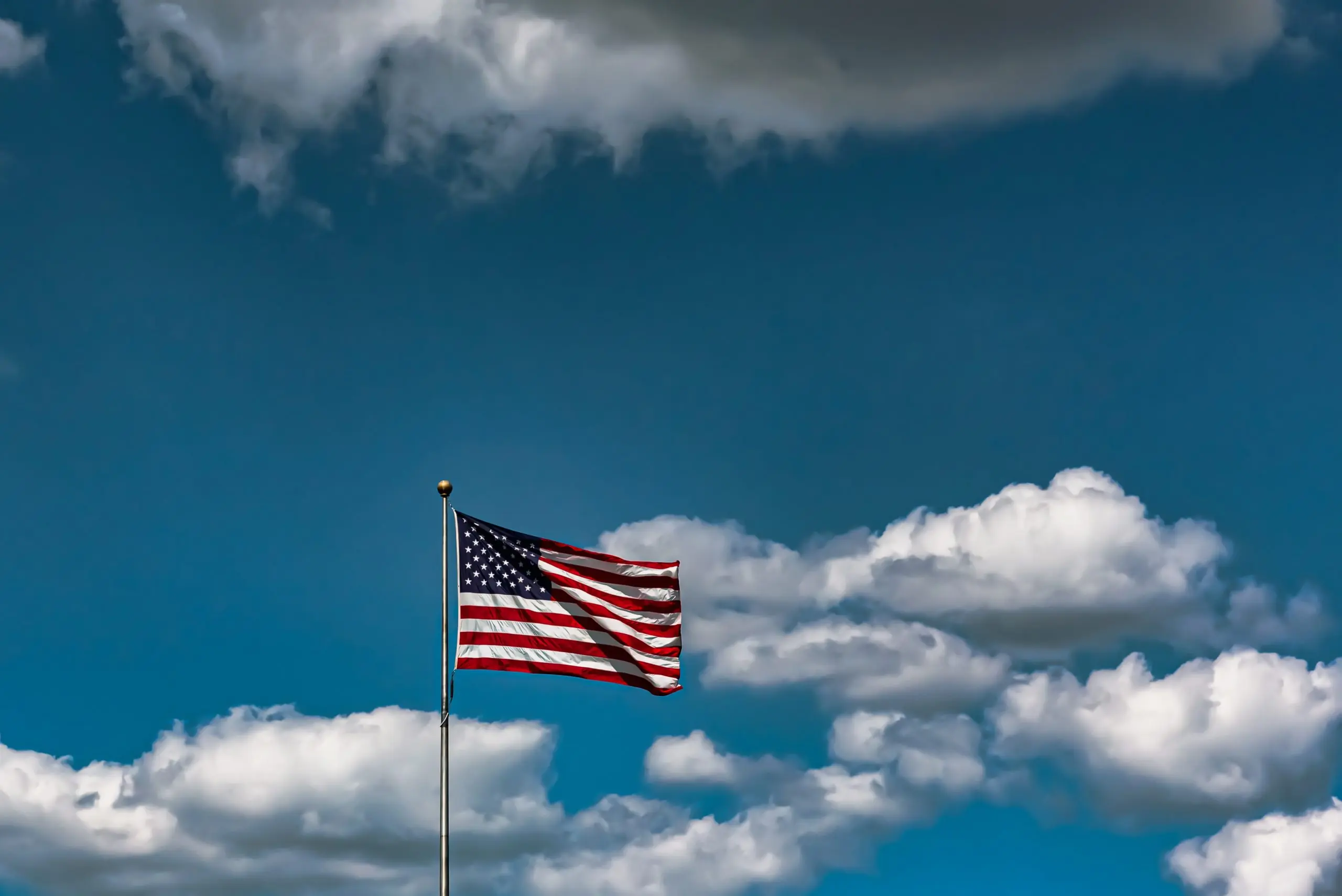 Closeup shot of the American flag waving in the air under a cloudy sky Closeup shot of the American flag waving in the air under a cloudy sky; roseville 4th of july